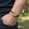 Bracelet en bois avec pendentif gravé du symbole Viking Vegvisir, porté au poignet avec un cordon noir tressé