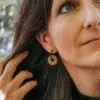 Boucles d'oreilles créoles en bois suisse avec un symbole caché dit "La vie est belle"