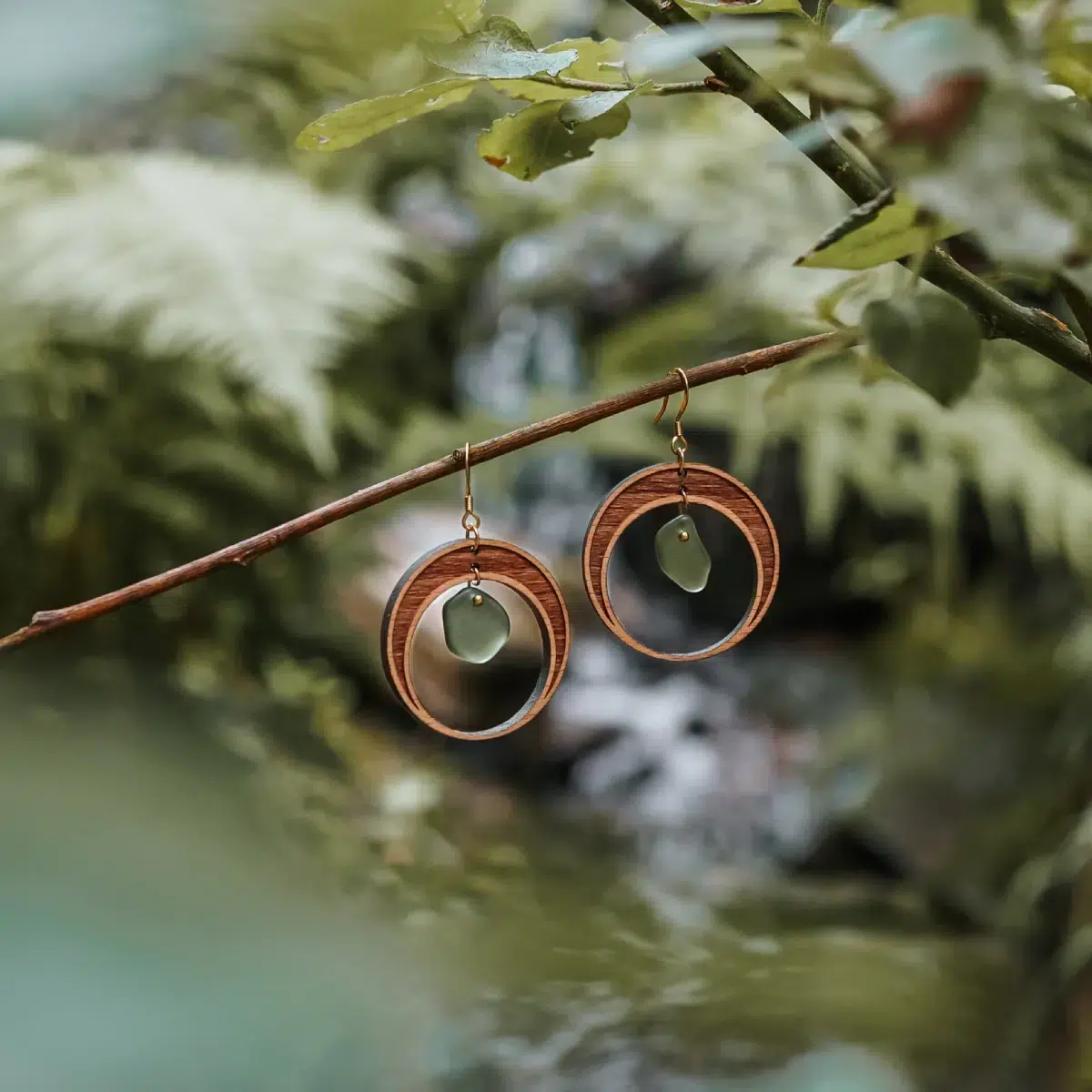 Boucles d'oreilles en bois et verre recyclé en forme de demi lune avec un verre vert